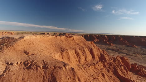 Low-aerial-drone-shot-over-the-flaming-cliffs-Bayanzag-Mongolia-sunset-time